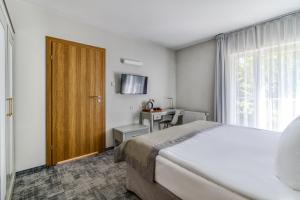 a bedroom with a bed and a desk and a window at Hotel Aqua Sopot - Destigo Hotels in Sopot
