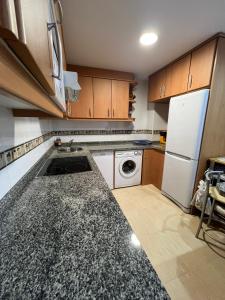 a kitchen with a white refrigerator and a dishwasher at Gestiona2R - Apartamento para dos céntrico en Nueva de Llanes in Nueva de Llanes