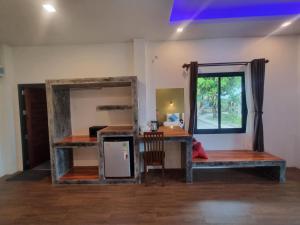 a room with a bed and a desk and a window at Sunny House Garden in Phra Ae beach