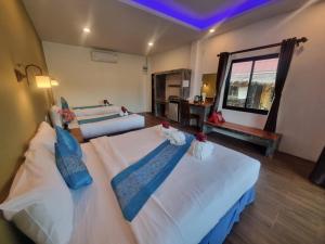 a bedroom with two beds and a window at Sunny House Garden in Phra Ae beach