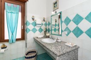 a bathroom with a sink and a mirror at Appartamento Confortevole nel cuore del centro storico in Orosei