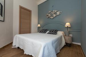 a bedroom with a white bed with two pillows on it at Appartamento Confortevole nel cuore del centro storico in Orosei