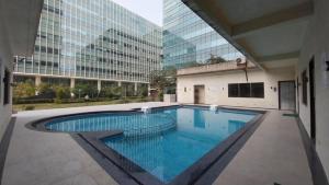 a swimming pool in the middle of a building at Aarya Stays- 1BHK near Jupiter Hospital in Thane