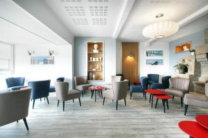 a waiting room with chairs and tables at Hôtel La Petite Sirène Quiberon in Quiberon