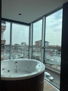 a bath tub in a room with a large window at Grand Armada Hotel in Avcılar