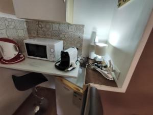 una piccola cucina con forno a microonde su un bancone di Medea rooms palermo centro a Palermo