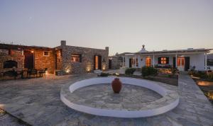 a patio with a vase in the middle of it at Onar Sifnos Stone Villa in Sifnos