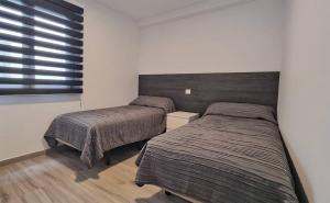 a bedroom with two beds and a window at Costa azul - 3 Izquierda in Puerto Naos