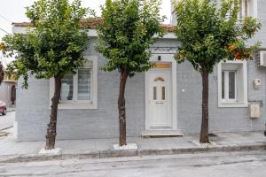 a gray building with trees in front of it at Aurum Residence in Volos