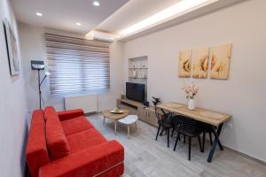 a living room with a red couch and a table at Aurum Residence in Volos