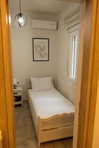 a small bedroom with a bed and a window at Aurum Residence in Volos