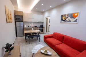 a living room with a red couch and a kitchen at Aurum Residence in Volos