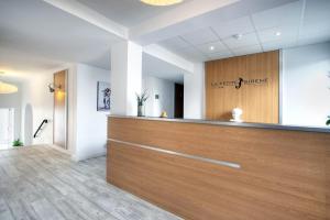 a salon with a wooden reception desk in a room at Hôtel La Petite Sirène Quiberon in Quiberon