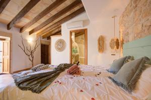a large bed in a room with a stone wall at Hotelet Can Oms Picasso by Rentallorca in Petra