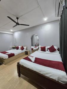 古瓦哈提Hotel Pohor Regency Near Kamakhya Gate Foot Bridge的带两张床和吊扇的卧室