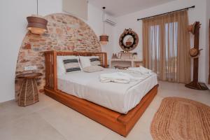 a bedroom with a bed and a stone wall at Onar Sifnos Stone Villa in Sifnos