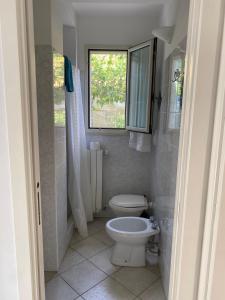 a bathroom with a toilet and a window at Casa al mare in Sperlonga