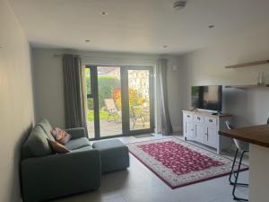 a living room with a couch and a sliding glass door at Nile Lodge in Galway