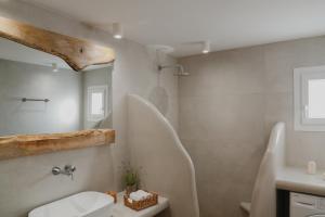 a bathroom with a white toilet and a sink at Onar Sifnos Stone Villa in Sifnos +52 photos