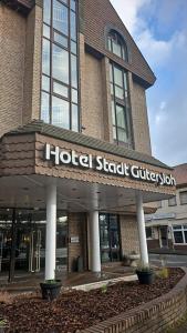 a hotel shard building with a sign in front of it at Hotel Stadt Gütersloh in Gütersloh