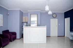 a living room with blue walls and a counter at Avenue Inn in Gaborone