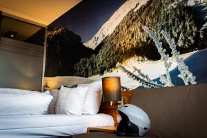 a bedroom with two beds and a painting on the wall at Alpine Hotel by SnowWorld in Landgraaf +20 photos