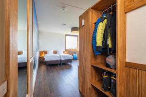 a room with a bedroom with a bed and a closet at Alpine Hotel by SnowWorld in Landgraaf