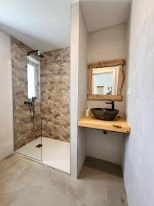 Un baño con ducha con lavabo y espejo. en CORRALEJO SURF HOUSE & SURF SCHOOl, en Corralejo