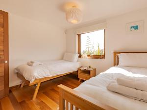 ein Schlafzimmer mit zwei Betten und einem Fenster in der Unterkunft 5 Bed in Ilfracombe 58766 in Ilfracombe