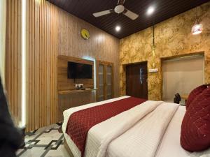 a bedroom with a bed and a television in it at Hotel Ambassador Varanasi in Varanasi