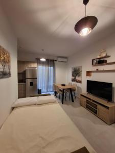 a bedroom with a large bed and a dining room at Markella's apartment Karystos in Karistos