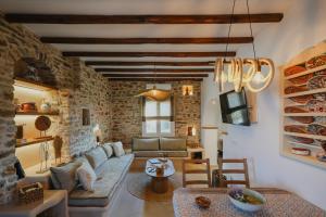 a living room with a couch and a table at Onar Sifnos Stone Villa in Sifnos