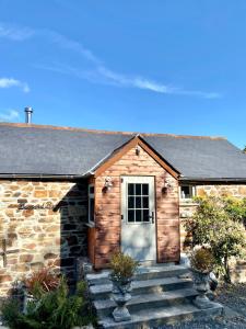 a stone house with a white door and stairs at Riverside barn on private wildlife estate in Washaway