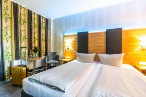 a hotel room with a large bed and a desk at Seehotel Forst in Forst