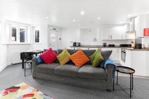 a living room with a couch with colorful pillows at The Hamlet - North East Escapes in Tynemouth