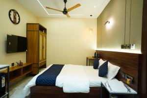 a hotel room with a bed and a flat screen tv at Hotel Ambassador Varanasi in Varanasi +37 photos