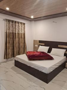 a bedroom with a bed with a red blanket on it at Badrish Kailasham By StayApart in Badrīnāth