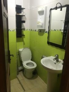 Un baño verde con inodoro y lavabo. en Appartement Familial pres la nouvelle gare routière & Grand Stade de Tanger, en Tánger 11 fotos más