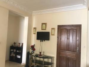 Una habitación con una puerta y una mesa con una lámpara. en Appartement Familial pres la nouvelle gare routière & Grand Stade de Tanger, en Tánger