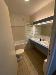a bathroom with two sinks and a toilet and a mirror at auberge des trois ami-es in Vinezac