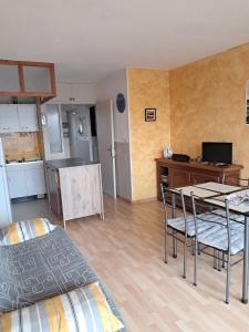 a living room with a table and chairs and a kitchen at Tamaris 42 in Quend-Plage +2 photos