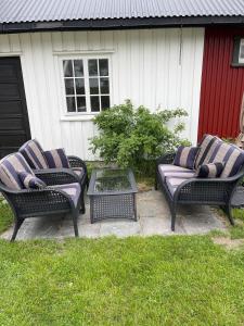 two wicker chairs and a table in front of a house at Recently Refurbished Farm House in Larvik