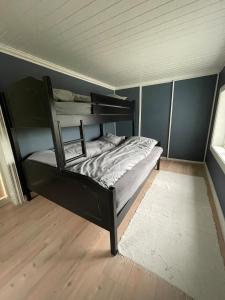 a bedroom with a black bunk bed in a room at Recently Refurbished Farm House in Larvik