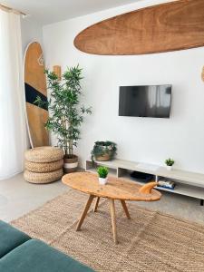 sala de estar con mesa de centro frente a una TV en CORRALEJO SURF HOUSE & SURF SCHOOl, en Corralejo 18 fotos más