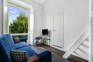 a living room with a blue couch and a window at Le Cocon - Studio Proche Disney & Paris - Wifi in Lagny