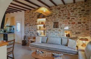 a living room with a couch and a stone wall at Onar Sifnos Stone Villa in Sifnos