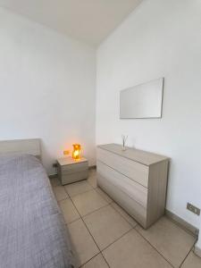 a bedroom with a bed and a dresser with a lamp at Portello Flat with Balcony in Milan