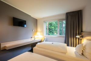 ロートガウにあるSerways Hotel Weiskirchen Nordのベッドと窓のあるホテルの部屋 +37枚の写真