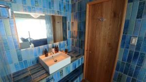 a blue tiled bathroom with a sink and a mirror at 那須パラダイスヴィレッジ Hotel PARADISO in Nasushiobara
