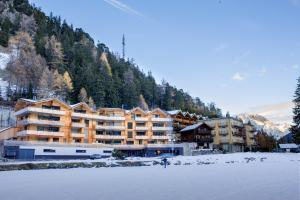 un grand bâtiment en face d'une montagne dans l'établissement Hotel Mont.Lac, à Champex-Lac